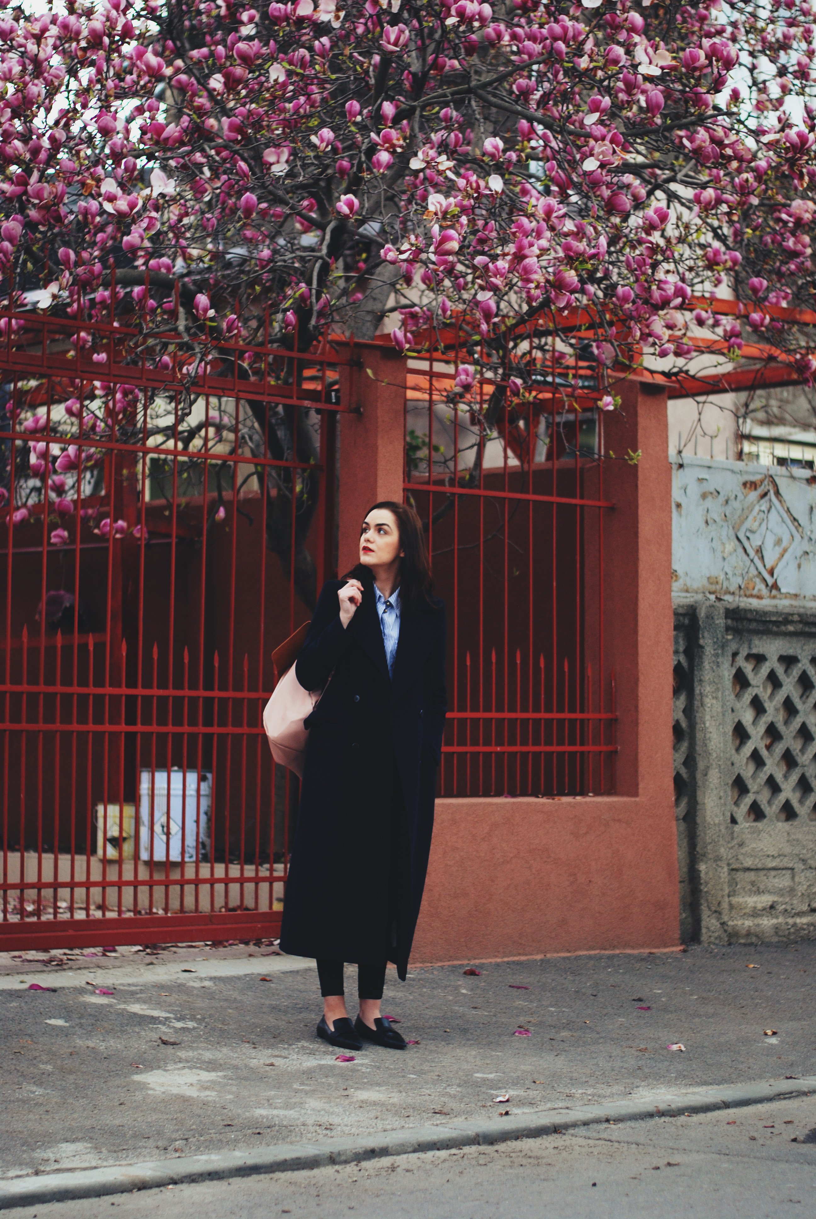 Navy long coat, striped shirt, pink backpack, black distressed jeans, loafers by Andreea Birsan