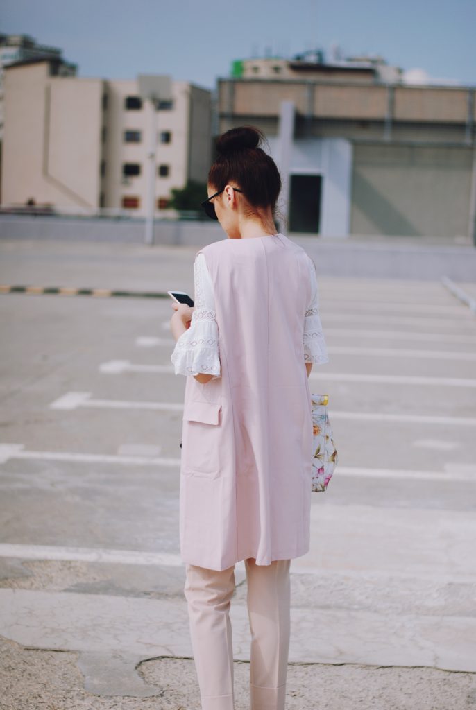 Pink trousers, lace cutout white blouse, black sunglasses, pink waistcoat vest, gold metallic oxford shoes, flower print bag, cute pink summer outfit, Andreea Birsan