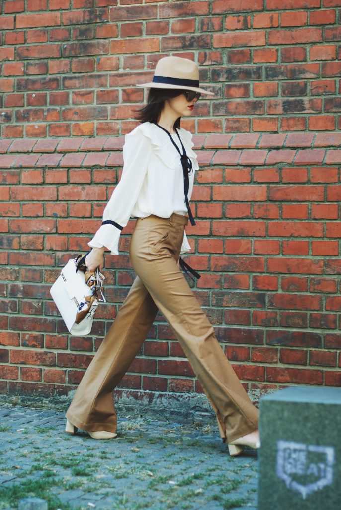 Camel fedora hat, camel flared pants trousers, ruffle top, scarf, white crossbody bag, beige pumps, dior sunglasses, cute autumn outfit idea, Andreea Birsan