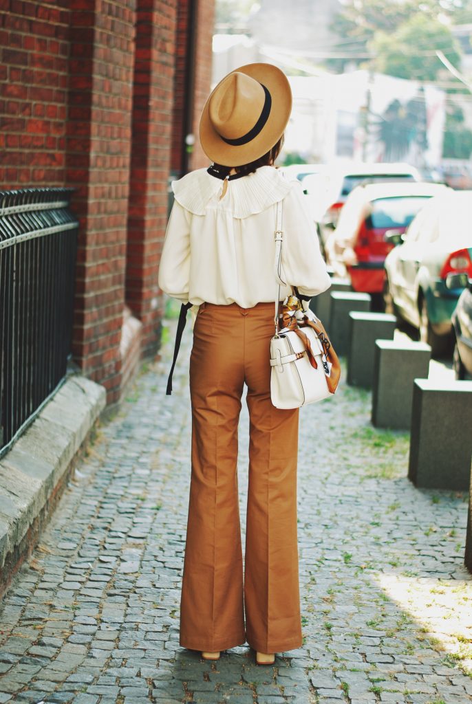 Camel fedora hat, camel flared pants trousers, ruffle top, scarf, white crossbody bag, beige pumps, dior sunglasses, cute autumn outfit idea, Andreea Birsan