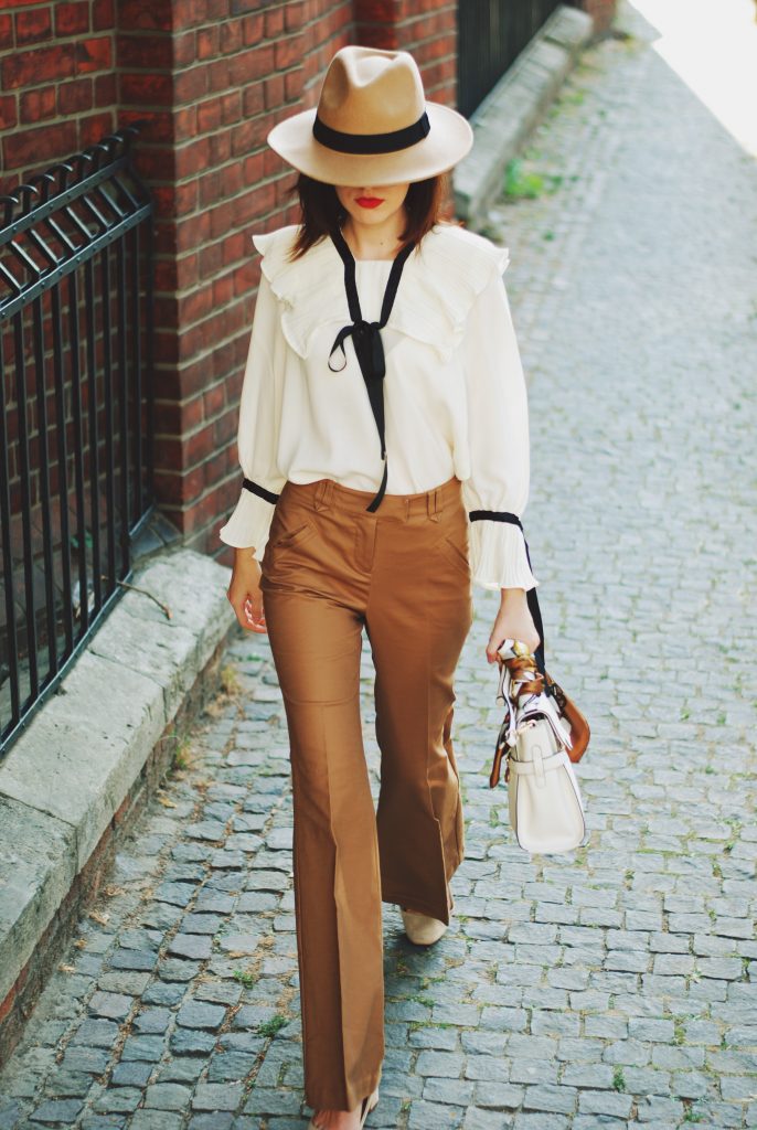 Camel fedora hat, camel flared pants trousers, ruffle top, scarf, white crossbody bag, beige pumps, dior sunglasses, cute autumn outfit idea, Andreea Birsan