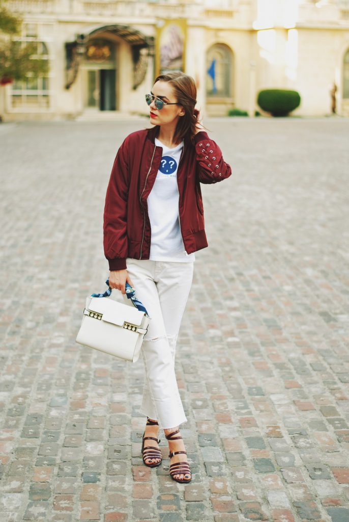 Lace up burgundy bomber jacket, white jeans, strappy sandals, white crossbody bag, sunglasses, fall outfit idea, Andreea Birsan