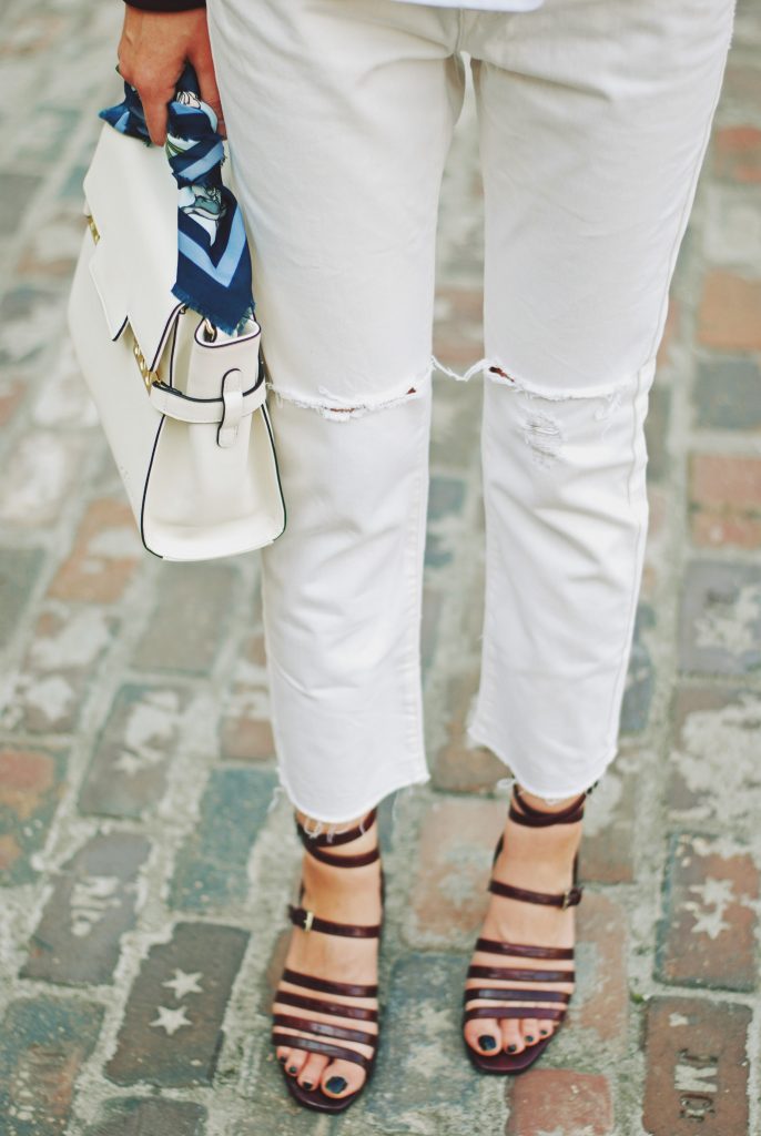 Lace up burgundy bomber jacket, white jeans, strappy sandals, white crossbody bag, sunglasses, fall outfit idea, Andreea Birsan