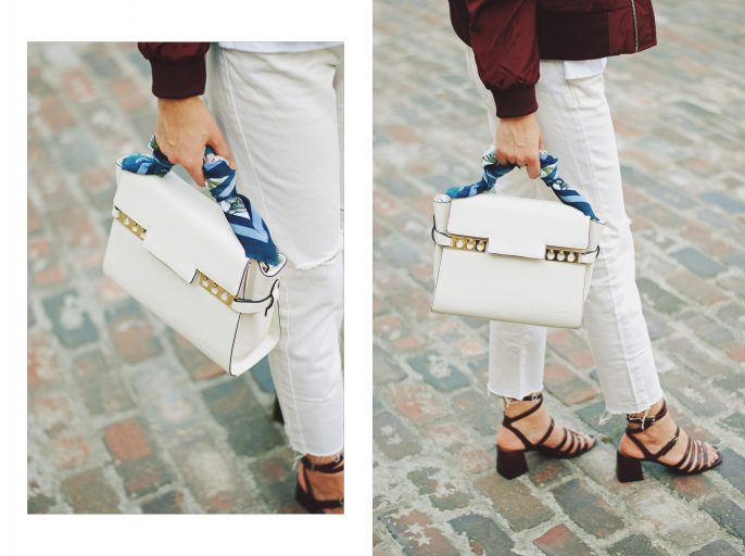 Lace up burgundy bomber jacket, white jeans, strappy sandals, white crossbody bag, sunglasses, fall outfit idea, Andreea Birsan