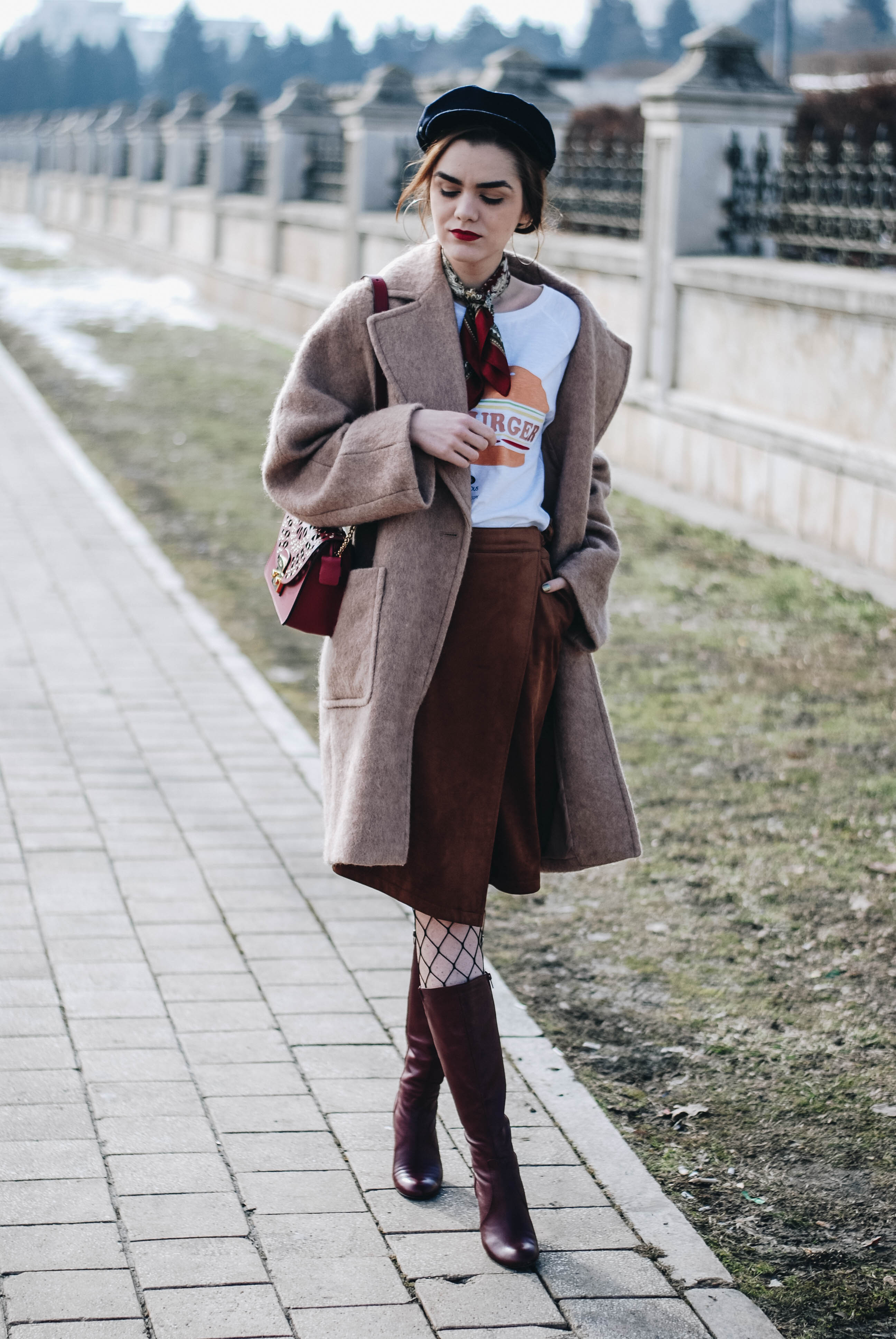 Brown suede midi wrap skirt, graphic tee, fishnet tights, zara navy military hat, tommy hilfiger knee high burgundy boots, furla metropolis red bag, H&M camel beige coat, silver hoop earrings andreea birsan, couturezilla, asos, mango, graphic tshirt, silky scarf, how to look parisian, topshop, fresh casual winter outfit ideas, what to wear a wrap skirt with, how to style knee high boots, pinterest outfits, tumblr outfit, ootd, european fashion blogger, romanian fashion blog