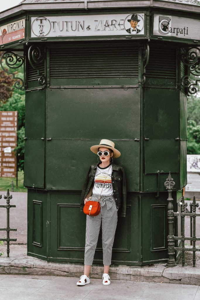 Zara paperbag striped pants with tie bow in front, mango retro graphic tee, asos printed tee, t-shirt, ace gucci sneakers, white leather sneakers, gucci sneakers with hearts, white kicks, chloe drew red crossbody bag, chloe drew lookalike bag, topshop straw hat, levis leather trucker jacket, genuine leather jacket, button down, silver hoop earrings, messy hair, bun, red lipstick, rivers island white sunglasses, retro sunglasses, sunnies, andreea birsan, couturezilla, cute spring outfit ideas for women 2017, how to wear striped pants, stripe trousers, what to wear stripe pants with, cute tumblr girls, the best outfit ideas for spring and summer, fashionista, fashion inspiration, european spring street style, romanian fashion blog, european fashion blogger, casual off duty style, chic on a budget, minimal outfits for women, ootd, outfit of the day, fashion trends for 2017, style inspiration, inspo, classy, casual pinterest outfit for women, what i wore, how to dress when you're uninspired