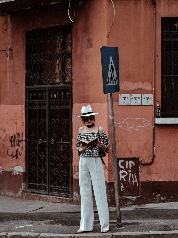 Zara white wide leg pants, crepe trousers, white palazzo pants, french women, fashion editorial, white trousers, what pants to wear in summer, what to wear when it's too hot, european summer outfits, asos gingham off shoulder gingham top, ots top, off the shoulder blouse, gingham, check print, vichy top, bardot gingham top, chicwish crop top, h&m ruffled top, frill, mango ruffle summer top, forever 21 cutest summer outfit for girls, what to wear when traveling, traveler outfit, havana, cuba, urban outfitters white straw hat, white and black outfit for summer 2017, river island fedora hat, topshop suede beige pumps, black mini bag, micro bag trend, black leather furla metropolis bag, new collection, fashion, leather crossbody bag, vintage reclaimed round black sunglasses, skinny scarf, neck scarf, how to look parisian, italiana, black skinny scarf, book, reading list, what to read, andreea birasn, couturezilla, sterling silver hoop earrings, silver, jewelry, statement earrings, vintage earrings, vintage inspired, american style, european summer outfit 2017, uk fashion blogger, united kingdom fashion blogger, fashionista, women with style, chic outfit ideas for women 2017, ootd, outfit inspiration, outfit of the day, cute pinterest outfit for women, minimal outfit inspo, girl, girls, women, cool kids, girls of tumblr, photos, european fashion blogger, european fashion blog, uk blog, fashion trends for summer 2017, how to wear the wide leg pants trend, palazzo pants what to wear them with, chic on a budget, zara outfit, styling tips and hacks, how to look parisian chic, casual outfit for women on holiday, how to wear gingham, print, red lipstick sephora, matte, erborian foundation, suede mules, nude mules, beige mules, pointy toe shoes, how to wear mules, instagram andreea birsan, style inspiration, inspo, summer in europe