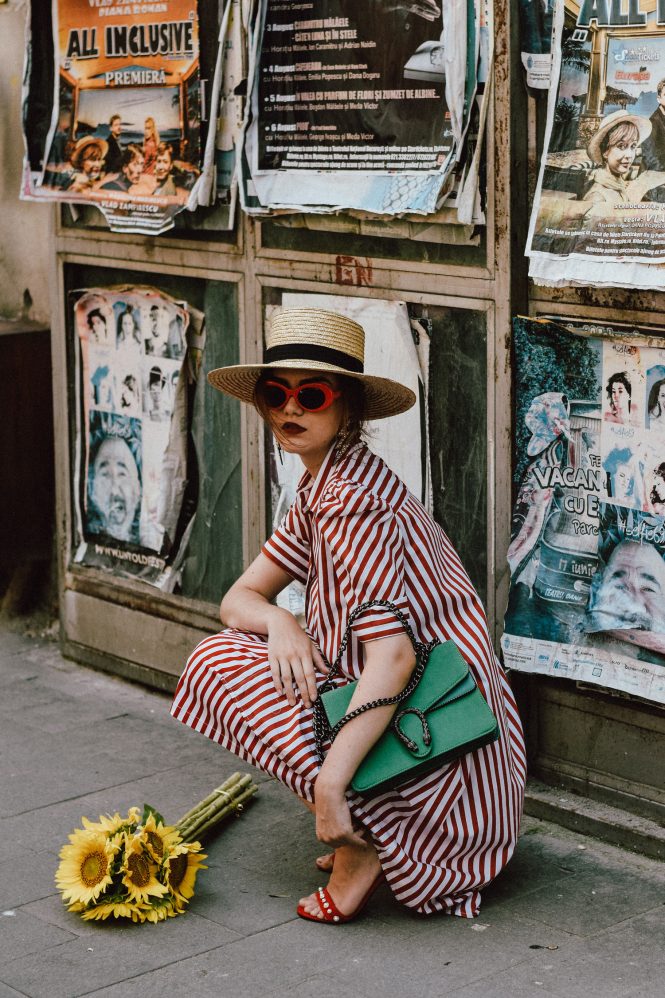 Zara red and white midi striped dress, Asos vertical striped dress, topshop stripe button down shirt dress, retro sleeves dress, puffy sleeves, mango striped red and white midi skirt, urban outfitters circle skirt, red velvet pearl embellished sandals, shoes with pearls, the pearls trend on shoes, red oval kurt cobain sunglasses, nirvana red sunglasses, green suede gucci dyonisus bag lookalike, emerald green shoulder bag, where to find the best alternative to the expensive gucci bags, gucci dyonisus dupe bag, straw boater hat, andreea birsan, couturezilla, cute summer outfit ideas 2017, statement earrings, sunflowers bouquet, how to wear all red like a pro, all red summer outfit, the best way to layering in summer, the easy way to layer in summer, how to wear a dress over a skirt, tips on wearing a dress over a skirt, summer layering, sunflower bouquet, the shoes that are all over instagram, the zara sold out dress, where to find this zara dress, how to wear red and green together, red and green outfit, all red summer outfit for women, how to rock an all red outfit, modern retro outfit, urban vibe, how to look Parisian chic, European summer street style inspiration for women 2017, pinterest chic outfit ideas for woman, summer outfit ideas, summer ootd inspiration, outfit of the day, ootd, fashion icon, style inspiration, fashionista, fashion inspiration, style inspo, what to wear in summer, how to look French, chic on a budget, zara outfit, mango, topshop, asos, river island, forever 21, urban outfitters, how to mix high end pieces with luxury ones, zara and Gucci, how to look chic when not wearing a dress, outfit alternatives for summer, tomboy chic, minimal outfit, tumblr girls photos, pictures, happy girl, women, smart casual outfits, the best outfit ideas 2017, what to wear when you don’t feel inspired, summer in Europe, weekend attire, uniform, French women in summer, European outfit ideas 2017, minimal chic outfit, how to stand out, the best outfit ideas for summer, the sunglasses you have seen everywhere on Instagram, glasses, uk fashion blogger, united kingdom, uk fashion blog, fashion and travel blog, Europe, women with style, street style, summer fashion trends 2017