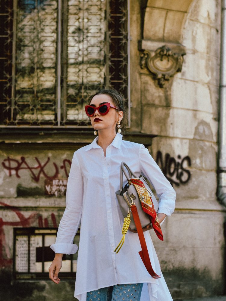 Zara white waterfall asymmetric shirt, white button down shirt, asymmetric shirt asos, where to find the best shirt dress, mango eyelet mom jeans, levi’s light wash mom jeans, 501 ct, jeans with eyelets, eyelet detail denim, statement denim, statement jeans, longline white button down shirt stradivarius, public desire pearl red sandals, srappy pearl embellished red sandals, coral red shoes, block heel sandals, best heel size for summer, statement shoes,, radley grey tote bag, leather medium everyday bag, work-life bag, best everyday bag for women, red cat eye sunglasses, cat eye sunglasses for women, statement sunglasses, retro inspired sunglasses, andreea birsan, couturezilla, cute summer outfit inspiration 2017. how to wear a dress over pants, dress over jeans trend, what to wear with a dress, the best outfit ideas, easy to pull together work outfit, what to wear to work in summer, how to stand out, leather bag, statement accessories, pearl trend, pearl earrings, statement earrings, where to find the popular instagram jeans, the best eyelet jeans, the chic white shirt, how to look Parisian chic, European summer street style inspiration for women 2017, pinterest chic outfit ideas for woman, summer outfit ideas, summer ootd inspiration, outfit of the day, ootd, fashion icon, style inspiration, fashionista, fashion inspiration, style inspo, what to wear in summer, how to look French, chic on a budget, zara outfit, mango, topshop, asos, river island, forever 21, urban outfitters, how to mix high end pieces with luxury ones, zara and Gucci, how to look chic when not wearing a dress, outfit alternatives for summer, tomboy chic, minimal outfit, tumblr girls photos, pictures, happy girl, women, smart casual outfits, the best outfit ideas 2017, what to wear when you don’t feel inspired, summer in Europe, weekend attire, uniform, French women in summer, European outfit ideas 2017, minimal chic outfit, how to stand out, the best outfit ideas for summer, the sunglasses you have seen everywhere on Instagram, glasses, uk fashion blogger, united kingdom, uk fashion blog, fashion and travel blog, Europe, women with style, street style, summer fashion trends 2017, best fashion ideas, styling, style inspiration, ootd on a budget