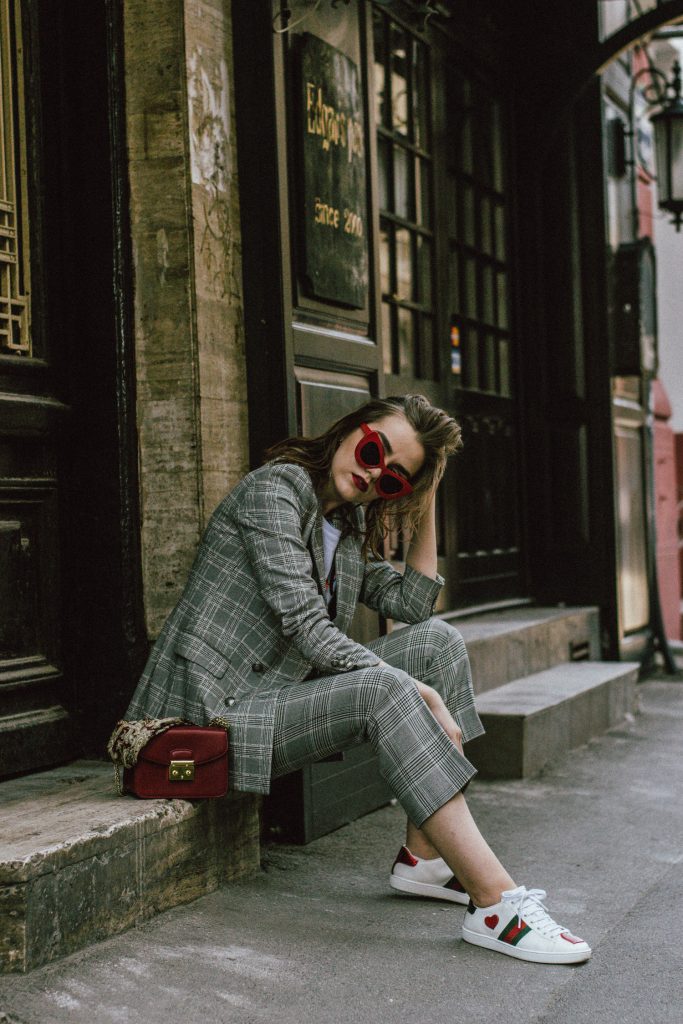 Zara check printed suit, mango check printed blazer,topshop checked flared trousers, checked suit, cropped trousers, gucci white ace heart embroidered sneakers, furla metropolis red bag, coke tee, coca cola t-shirt, andreea birsan, couturezilla, cute fall outfit ideas 2017, check suit, edgy outfit for women, silk scarf, red retro sunglasses, big sunglasses, tomboy chic outfit, how to style a suit, what to wear with a women suit, how to make a suit look casual chic, how to make an outfit look edgy, how to wear a suit with sneakers, sneakers and suits, white shoes, white leather sneakers, statement sneakers, lips printed earrings, statement earrings, red cat eye sunglasses, sunnies, fall outfit ideas for women 2017, transitional outfit ideas, transitional ootd, transitioning into autumn, autumn 2017, moody photoshoot, how to look Parisian chic, European summer street style inspiration for women 2017, pinterest chic outfit ideas for woman, summer outfit ideas, summer ootd inspiration, outfit of the day, ootd, fashion icon, style inspiration, fashionista, fashion inspiration, style inspo, what to wear in summer, how to look French, chic on a budget, zara outfit, mango, topshop, asos, river island, forever 21, urban outfitters, how to mix high end pieces with luxury ones, zara and Gucci,outfit alternatives for summer, tomboy chic, minimal outfit, tumblr girls photos, pictures, happy girl, women, smart casual outfits, the best outfit ideas 2017, what to wear when you don’t feel inspired, summer in Europe, weekend attire, uniform, French women in summer, European outfit ideas 2017, minimal chic outfit, how to stand out, the best outfit ideas for summer, the sunglasses you have seen everywhere on Instagram, glasses, uk fashion blogger, united kingdom, uk fashion blog, fashion and travel blog, Europe, women with style, street style, summer fashion trends 2017, best fashion ideas, styling, fall in europe