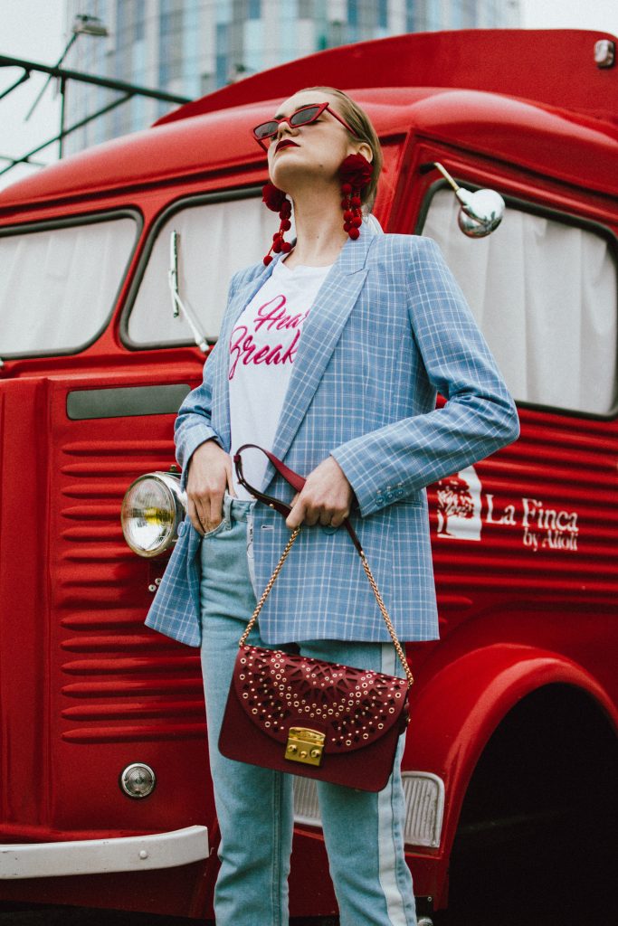 Baby blue checked blazer, statement jeans, furla metropolis red bag, small sunglasses, tee, andreea birsan, couturezilla, cute spring outfit ideas 2018, baby blue blazre, how to wear pastels this spring, jeans with constrastic side panel, redone jeans, reconstructed jeans trend, how to wear reconstructed jeans, red pom pom statement earrings, small cat eye sunglasses in red, retro small sunglasses, small sunnies, matrix sunglasses trend, micro sunglasses trend, red earrings, red and baby blue outfit, how to wear the white shoes trend, white leather high heels, white chuncky heel shoes, white pumps, heart breaker t-shirt, printed tshirt, printed tee, graphic t-shirt, furla red lace cut out metropolis bag, furla leather shoulder bag, furla red metropolis, furla large metropolis bag in red, how to style a furla bag, perfect spring outfit for work and hanging out, red food van, how to look Parisian chic, European summer street style inspiration for women 2017, pinterest chic outfit ideas for woman, summer outfit ideas, summer ootd inspiration, outfit of the day, ootd, fashion icon, style inspiration, fashionista, fashion inspiration, style inspo, what to wear in summer, how to look French, chic on a budget, zara outfit, mango, topshop, asos, river island, forever 21, urban outfitters, how to mix high end pieces with luxury ones, zara and Gucci,outfit alternatives for summer, tomboy chic, minimal outfit, tumblr girls photos, pictures, happy girl, women, smart casual outfits, the best outfit ideas 2017, what to wear when you don’t feel inspired, summer in Europe, weekend attire, uniform, French women in summer, European outfit ideas 2017, minimal chic outfit, how to stand out, the best outfit ideas for summer, the sunglasses you have seen everywhere on Instagram, glasses, uk fashion blogger, united kingdom, uk fashion blog, fashion and travel blog, Europe, women with style, street style, summer fashion trends 2017, best fashion ideas, styling, fall fashion, fall outfit, fall ootd, fall perfect, transitional dressing, best transitional outfit ideas, how to wear statement earrings, dressing for autumn, autumn outfit, winter outfit ideas for work and school 2017