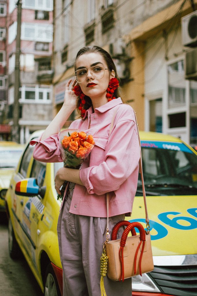 Pastels, pink denim jacket, purple trousers, white shoes, statement earrings, andreea birsan, couturezilla, cute spring outfit ideas 2018, pink and purple spring outfit ideas for 2018, pink cropped cotton jacket, pink trucker jacket, cropped pink denim jacket from na-kd, nakd jacket, mango white camisole top, cami tank top, basic white cami, how to wear a white cami top, how to wear pastels this spring, the pastels fashion trend, head to toe pastels, statement bag, multicolor bag, mini bag, micro tote bag, dusty pink bag, blush pink bag, red statement earrings, earrings with pom poms, xxl earrings, aviator clear lens glasses, the instagram clear lens glasses trend, purple high waisted peg trousers, the best mango trousers, linen and cotton, white leather pumps with block heel, white leather shoes, the white shoes trend, liliac, violet trousers, liliac pants, pastel pants, peg trousers, high waisted trousers with belt detail, how to look Parisian chic, European summer street style inspiration for women 2017, pinterest chic outfit ideas for woman, summer outfit ideas, summer ootd inspiration, outfit of the day, ootd, fashion icon, style inspiration, fashionista, fashion inspiration, style inspo, what to wear in summer, how to look French, chic on a budget, zara outfit, mango, topshop, asos, river island, forever 21, urban outfitters, how to mix high end pieces with luxury ones, zara and Gucci,outfit alternatives for summer, tomboy chic, minimal outfit, tumblr girls photos, pictures, happy girl, women, smart casual outfits, the best outfit ideas 2017, what to wear when you don’t feel inspired, summer in Europe, weekend attire, uniform, French women in summer, European outfit ideas 2017, minimal chic outfit, how to stand out, the best outfit ideas for summer, the sunglasses you have seen everywhere on Instagram, glasses, uk fashion blogger, united kingdom, uk fashion blog, fashion and travel blog, Europe, women with style, street style, summer fashion trends 2017, best fashion ideas, styling, fall fashion, fall outfit, fall ootd, fall perfect, transitional dressing, best transitional outfit ideas, how to wear statement earrings, dressing for autumn, autumn outfit, winter outfit ideas for work and school 2017