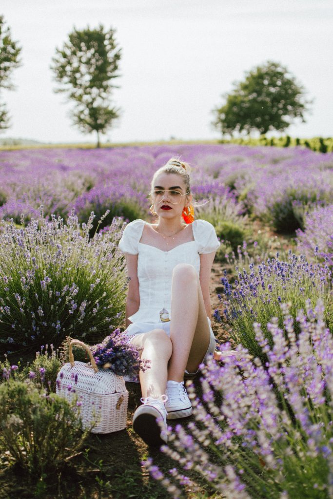 Bershka white button detail top with puffy sleeves, white shorts, tvintage inspired chain belt, chain belt, vintage, ommy hilfiger white textile summer sneakers, white straw bag, lavender field, andreea birsan, cute summer outfit ideas 2018, tommy trainers, white trainers, all white outfit for summer 2018, scarf in hair, how to style a scarf in your hair, lavender fields in romania, lan de lavanda, lavanda, levantica, lavender, purple, wicker bag, straw bag, the best summer bag, raffia bag, hand made bamboo bag, white straw bag limited edition, limited edition mango bag, gold accessories, layered necklaces, clear lens aviator glasses, all white, small hoop earrings, french inspired outfit, provence, romania, beautiful vintage inspired top, button detail top, blouse, the perfect summer blouse, cutest summer tops, how to wear all white like a pro, white top, white cotton shorts, airy shorts, cute women shorts, linen and cotton, white button detail top, peplum top, how to look Parisian chic, European summer street style inspiration for women 2017, pinterest chic outfit ideas for woman, summer outfit ideas, summer ootd inspiration, outfit of the day, ootd, fashion icon, style inspiration, fashionista, fashion inspiration, style inspo, what to wear in summer, how to look French, chic on a budget, zara outfit, mango, topshop, asos, river island, forever 21, urban outfitters, how to mix high end pieces with luxury ones, zara and Gucci,outfit alternatives for summer, tomboy chic, minimal outfit, tumblr girls photos, pictures, happy girl, women, smart casual outfits, the best outfit ideas 2017, what to wear when you don’t feel inspired, summer in Europe, weekend attire, uniform, French women in summer, European outfit ideas 2017, minimal chic outfit, how to stand out, the best outfit ideas for summer, the sunglasses you have seen everywhere on Instagram, glasses, uk fashion blogger, united kingdom, uk fashion blog, fashion and travel blog, Europe, women with style, street style, summer fashion trends 2017, best fashion ideas, styling, fall fashion, fall outfit, fall ootd, fall perfect, transitional dressing, best transitional outfit ideas, how to wear statement earrings, dressing for autumn, autumn outfit, winter outfit ideas for work and school 2017, red scarf,