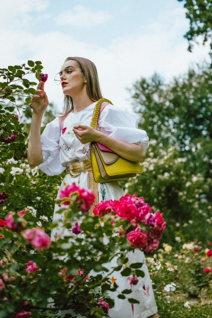 White puffy sleeves shirt, layered button front midi dress, gold metallic vintage belt, colorblock leather shoulder bag, pink mules, rose gorden editorial, andreea birsan, couturezilla, cute summer outfit ideas for 2018, step up your midi dress, how to wear a midi dress, printed dress, cotton dress, ottod’ame dress, rose gardens in bucharest, trandafiri bucuresti, gradina botanica, botanical garden, fun dress, cotton and linen, white shirt with puffy sleeves, the perfect midi dress for summer, marcie wconcept pink suede mules, korean shoes, korean mules, korean designer shoes, italian dress, beautiful bag, statement bag, yellow and pink shoulder bag, statement bag strap, isla fontaine bags, italian leather bags, how to layer a midi dress when it’s melting outside, the midi dress you should wear this summer, how to wear a puffy sleeve top, white shirt, wardrobe must have, staples, how to look Parisian chic, European summer street style inspiration for women 2017, pinterest chic outfit ideas for woman, summer outfit ideas, summer ootd inspiration, outfit of the day, ootd, fashion icon, style inspiration, fashionista, fashion inspiration, style inspo, what to wear in summer, how to look French, chic on a budget, zara outfit, mango, topshop, asos, river island, forever 21, urban outfitters, how to mix high end pieces with luxury ones, zara and Gucci,outfit alternatives for summer, tomboy chic, minimal outfit, tumblr girls photos, pictures, happy girl, women, smart casual outfits, the best outfit ideas 2017, what to wear when you don’t feel inspired, summer in Europe, weekend attire, uniform, French women in summer, European outfit ideas 2017, minimal chic outfit, how to stand out, the best outfit ideas for summer, the sunglasses you have seen everywhere on Instagram, glasses, uk fashion blogger, united kingdom, uk fashion blog, fashion and travel blog, Europe, women with style, street style, summer fashion trends 2017, best fashion ideas, styling, fall fashion, fall outfit, fall ootd, fall perfect, transitional dressing, best transitional outfit ideas, how to wear statement earrings, dressing for autumn, autumn outfit, winter outfit ideas for work and school 2017, clear lens aviator glasses, geeky glasses, clear lens glasses trend