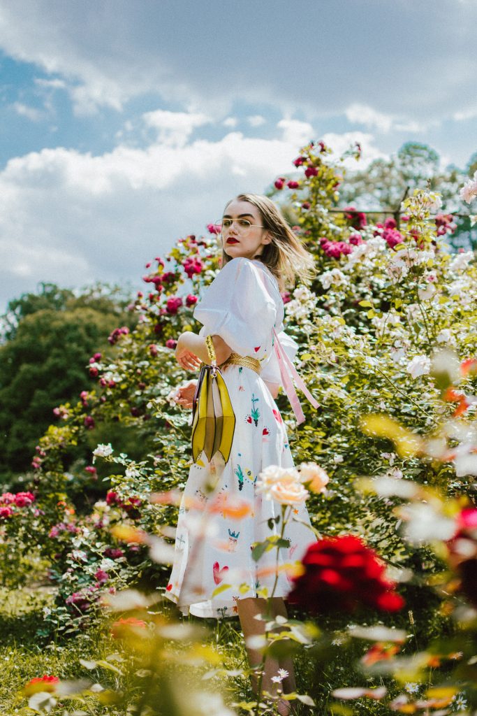 White puffy sleeves shirt, layered button front midi dress, gold metallic vintage belt, colorblock leather shoulder bag, pink mules, rose gorden editorial, andreea birsan, couturezilla, cute summer outfit ideas for 2018, step up your midi dress, how to wear a midi dress, printed dress, cotton dress, ottod’ame dress, rose gardens in bucharest, trandafiri bucuresti, gradina botanica, botanical garden, fun dress, cotton and linen, white shirt with puffy sleeves, the perfect midi dress for summer, marcie wconcept pink suede mules, korean shoes, korean mules, korean designer shoes, italian dress, beautiful bag, statement bag, yellow and pink shoulder bag, statement bag strap, isla fontaine bags, italian leather bags, how to layer a midi dress when it’s melting outside, the midi dress you should wear this summer, how to wear a puffy sleeve top, white shirt, wardrobe must have, staples, how to look Parisian chic, European summer street style inspiration for women 2017, pinterest chic outfit ideas for woman, summer outfit ideas, summer ootd inspiration, outfit of the day, ootd, fashion icon, style inspiration, fashionista, fashion inspiration, style inspo, what to wear in summer, how to look French, chic on a budget, zara outfit, mango, topshop, asos, river island, forever 21, urban outfitters, how to mix high end pieces with luxury ones, zara and Gucci,outfit alternatives for summer, tomboy chic, minimal outfit, tumblr girls photos, pictures, happy girl, women, smart casual outfits, the best outfit ideas 2017, what to wear when you don’t feel inspired, summer in Europe, weekend attire, uniform, French women in summer, European outfit ideas 2017, minimal chic outfit, how to stand out, the best outfit ideas for summer, the sunglasses you have seen everywhere on Instagram, glasses, uk fashion blogger, united kingdom, uk fashion blog, fashion and travel blog, Europe, women with style, street style, summer fashion trends 2017, best fashion ideas, styling, fall fashion, fall outfit, fall ootd, fall perfect, transitional dressing, best transitional outfit ideas, how to wear statement earrings, dressing for autumn, autumn outfit, winter outfit ideas for work and school 2017, clear lens aviator glasses, geeky glasses, clear lens glasses trend