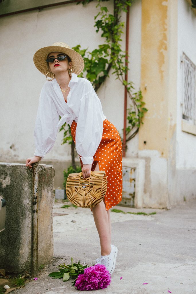 Orange boohoo midi polka dot midi dress, mango white balloon sleeve shirt shirt, h&m natural straw hat, cult gaia ark bag, tommy hilfiger white sneakers, andreea birsan, couturezilla, cute summer outfit ideas 2018. white trainers and dress, midi dress and sneakers, what to wear with a polka dot dress, midi polka dot dress with slit, orange dress, how to wear orange, what to wear with orange, rust color dress, what colors to wear this summer, how to wear sneakers and dresses, mixing feminine with masculine elements, athleisure, sexy polka dot dress, boater hat, cult gaia ark inspired bag, petite sardine bag, portuguese bag, bamboo bag, how to wear a white shirt, button up shirt, cotton shirt, how to layer in summer, layered summer dress, summer layers, white sneakers, white trainers, tommy hilfiger, gold accessories, small cat eye sunglasses, 90s inspired sunglasses, micro sunglasses trend, mini sunglasses, cat eye sunnies, the sold out asos sunglasses, chic bags to wear in spring and summer, raffia bag, straw bag, handmade bag, peonies, how to look Parisian chic, European summer street style inspiration for women 2017, pinterest chic outfit ideas for woman, summer outfit ideas, summer ootd inspiration, outfit of the day, ootd, fashion icon, style inspiration, fashionista, fashion inspiration, style inspo, what to wear in summer, how to look French, chic on a budget, zara outfit, mango, topshop, asos, river island, forever 21, urban outfitters, how to mix high end pieces with luxury ones, zara and Gucci,outfit alternatives for summer, tomboy chic, minimal outfit, tumblr girls photos, pictures, happy girl, women, smart casual outfits, the best outfit ideas 2017, what to wear when you don’t feel inspired, summer in Europe, weekend attire, uniform, French women in summer, European outfit ideas 2017, minimal chic outfit, how to stand out, the best outfit ideas for summer, the sunglasses you have seen everywhere on Instagram, glasses, uk fashion blogger, united kingdom, uk fashion blog, fashion and travel blog, Europe, women with style, street style, summer fashion trends 2017, best fashion ideas, styling, fall fashion, fall outfit, fall ootd, fall perfect, transitional dressing, best transitional outfit ideas, how to wear statement earrings, dressing for autumn, autumn outfit, winter outfit ideas for work and school 2017