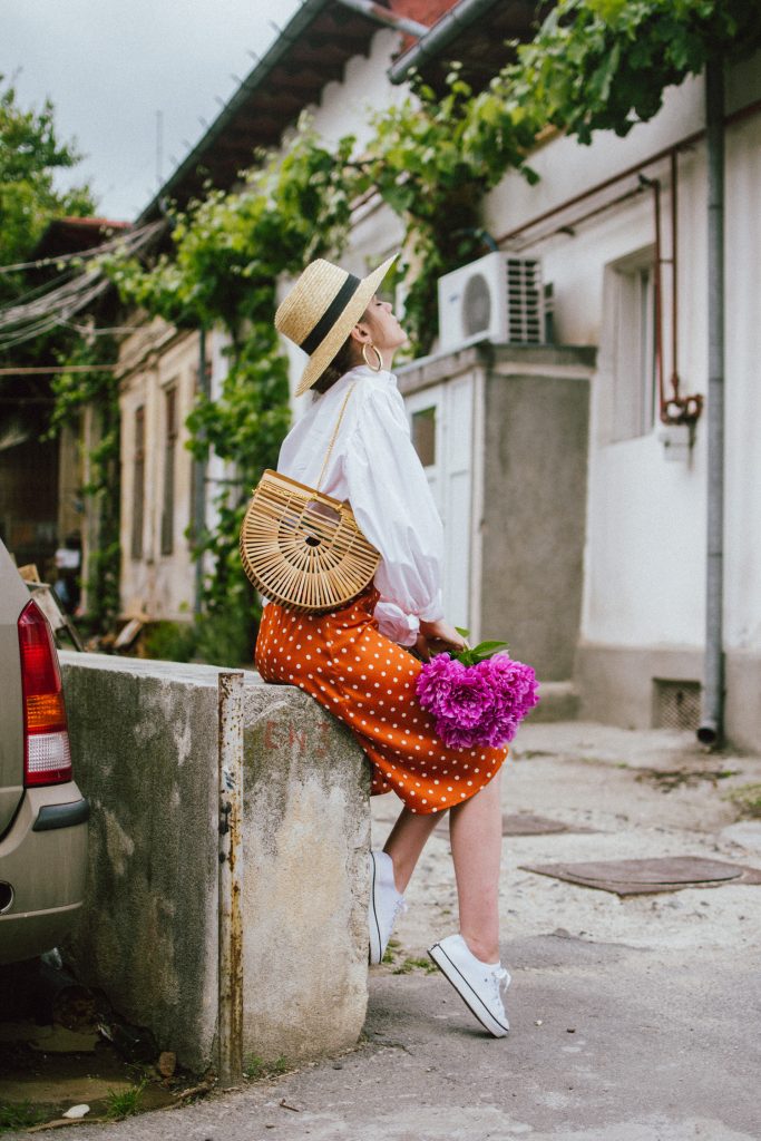 Orange boohoo midi polka dot midi dress, mango white balloon sleeve shirt shirt, h&m natural straw hat, cult gaia ark bag, tommy hilfiger white sneakers, andreea birsan, couturezilla, cute summer outfit ideas 2018. white trainers and dress, midi dress and sneakers, what to wear with a polka dot dress, midi polka dot dress with slit, orange dress, how to wear orange, what to wear with orange, rust color dress, what colors to wear this summer, how to wear sneakers and dresses, mixing feminine with masculine elements, athleisure, sexy polka dot dress, boater hat, cult gaia ark inspired bag, petite sardine bag, portuguese bag, bamboo bag, how to wear a white shirt, button up shirt, cotton shirt, how to layer in summer, layered summer dress, summer layers, white sneakers, white trainers, tommy hilfiger, gold accessories, small cat eye sunglasses, 90s inspired sunglasses, micro sunglasses trend, mini sunglasses, cat eye sunnies, the sold out asos sunglasses, chic bags to wear in spring and summer, raffia bag, straw bag, handmade bag, peonies, how to look Parisian chic, European summer street style inspiration for women 2017, pinterest chic outfit ideas for woman, summer outfit ideas, summer ootd inspiration, outfit of the day, ootd, fashion icon, style inspiration, fashionista, fashion inspiration, style inspo, what to wear in summer, how to look French, chic on a budget, zara outfit, mango, topshop, asos, river island, forever 21, urban outfitters, how to mix high end pieces with luxury ones, zara and Gucci,outfit alternatives for summer, tomboy chic, minimal outfit, tumblr girls photos, pictures, happy girl, women, smart casual outfits, the best outfit ideas 2017, what to wear when you don’t feel inspired, summer in Europe, weekend attire, uniform, French women in summer, European outfit ideas 2017, minimal chic outfit, how to stand out, the best outfit ideas for summer, the sunglasses you have seen everywhere on Instagram, glasses, uk fashion blogger, united kingdom, uk fashion blog, fashion and travel blog, Europe, women with style, street style, summer fashion trends 2017, best fashion ideas, styling, fall fashion, fall outfit, fall ootd, fall perfect, transitional dressing, best transitional outfit ideas, how to wear statement earrings, dressing for autumn, autumn outfit, winter outfit ideas for work and school 2017