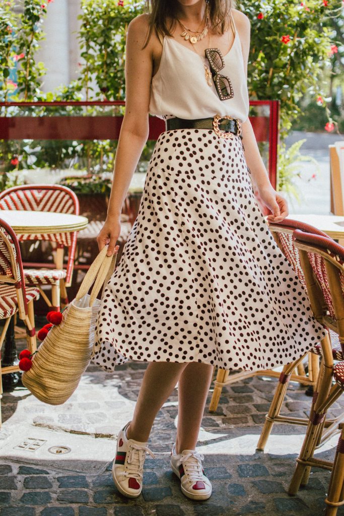 Zara polka dot skirt, white cami top, gucci ace heart sneakers, cherry pom pom straw summer bag, paris, andreea birsan, couturezilla, cute summer outfit ideas 2018, polka dot midi skirt, spaghetti straps white camisole top, mango white, white and black midi skirt, the zara sold out polka dot skirt, basic white cami top, how to wear a midi skirt, what to wear with a midi polka dot skirt, how to style a polka dot skirt, how to wear a polka dot skirt, gucci trainers, gucci ace heart embroidered sneakers, white trainers, heart embroidery, white leather shoes, parisian cafe, skirt and sneakers, shell accessories, shell necklaces, gold layered necklaces, gucci inspired embellished square sunglasses, 90s sunglasses, black sunglasses, printed silk scarf, clear lens aviator glasses, zara glasses, the geeky glasses trend, the clear lens glasses trend you’ve seen on instagram, popular glasses, gucci 90s inspired square embellished sunglasses with rhinestones, pom pom summer bag, straw bag, asos sold out summer bag, raffia tote bag, statement summer bag, how to look Parisian chic, European summer street style inspiration for women 2017, pinterest chic outfit ideas for woman, summer outfit ideas, summer ootd inspiration, outfit of the day, ootd, fashion icon, style inspiration, fashionista, fashion inspiration, style inspo, what to wear in summer, how to look French, chic on a budget, zara outfit, mango, topshop, asos, river island, forever 21, urban outfitters, how to mix high end pieces with luxury ones, zara and Gucci,outfit alternatives for summer, tomboy chic, minimal outfit, tumblr girls photos, pictures, happy girl, women, smart casual outfits, the best outfit ideas 2017, what to wear when you don’t feel inspired, summer in Europe, weekend attire, uniform, French women in summer, European outfit ideas 2017, minimal chic outfit, how to stand out, the best outfit ideas for summer, the sunglasses you have seen everywhere on Instagram, glasses, uk fashion blogger, united kingdom, uk fashion blog, fashion and travel blog, Europe, women with style, street style, summer fashion trends 2017, best fashion ideas, styling, fall fashion, fall outfit, fall ootd, fall perfect, transitional dressing, best transitional outfit ideas, how to wear statement earrings, dressing for autumn, autumn outfit, winter outfit ideas for work and school 2017