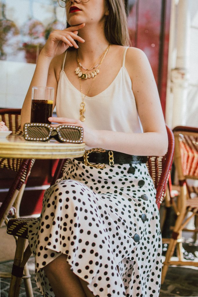 Zara polka dot skirt, white cami top, gucci ace heart sneakers, cherry pom pom straw summer bag, paris, andreea birsan, couturezilla, cute summer outfit ideas 2018, polka dot midi skirt, spaghetti straps white camisole top, mango white, white and black midi skirt, the zara sold out polka dot skirt, basic white cami top, how to wear a midi skirt, what to wear with a midi polka dot skirt, how to style a polka dot skirt, how to wear a polka dot skirt, gucci trainers, gucci ace heart embroidered sneakers, white trainers, heart embroidery, white leather shoes, parisian cafe, skirt and sneakers, shell accessories, shell necklaces, gold layered necklaces, gucci inspired embellished square sunglasses, 90s sunglasses, black sunglasses, printed silk scarf, clear lens aviator glasses, zara glasses, the geeky glasses trend, the clear lens glasses trend you’ve seen on instagram, popular glasses, gucci 90s inspired square embellished sunglasses with rhinestones, pom pom summer bag, straw bag, asos sold out summer bag, raffia tote bag, statement summer bag, how to look Parisian chic, European summer street style inspiration for women 2017, pinterest chic outfit ideas for woman, summer outfit ideas, summer ootd inspiration, outfit of the day, ootd, fashion icon, style inspiration, fashionista, fashion inspiration, style inspo, what to wear in summer, how to look French, chic on a budget, zara outfit, mango, topshop, asos, river island, forever 21, urban outfitters, how to mix high end pieces with luxury ones, zara and Gucci,outfit alternatives for summer, tomboy chic, minimal outfit, tumblr girls photos, pictures, happy girl, women, smart casual outfits, the best outfit ideas 2017, what to wear when you don’t feel inspired, summer in Europe, weekend attire, uniform, French women in summer, European outfit ideas 2017, minimal chic outfit, how to stand out, the best outfit ideas for summer, the sunglasses you have seen everywhere on Instagram, glasses, uk fashion blogger, united kingdom, uk fashion blog, fashion and travel blog, Europe, women with style, street style, summer fashion trends 2017, best fashion ideas, styling, fall fashion, fall outfit, fall ootd, fall perfect, transitional dressing, best transitional outfit ideas, how to wear statement earrings, dressing for autumn, autumn outfit, winter outfit ideas for work and school 2017