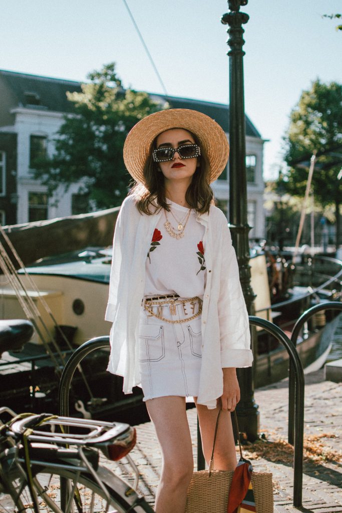 Contrast stitch white denim skirt, na-kd rose embroidered white t-shirt, linen shirt, straw bag, andreea birsan, couturezilla, cute summer outfit ideas 2018, zara mini denim skirt, rose shirt, nakd popular soldout rose embroidered tshirt, linen white shirt, boyfriend shirt, button up white shirt, oversized white shirt, how to wear a white shirt in a casual way, contrast stitching trend, the contrast stitch trend you need to try, how to up your basics, all white summer outfit, summer layering, gucci lookalike pearl sunglasses, 90s square sunglasses, statement sunglasses, budget alternative to gucci sunglasses, high street alternative, how to wear a mini skirt without looking vulgar, straw boater hat, straw hat, summer hat, wide brim hat, vintage straw tote bag, netherlands, visit netherlands, holland, schiedam, vintage finds, vintage raffia bag, vintage french bag, stripe silk scarf, tommy hilfiger red espadrilles, red shoes, red summer shoes, how to look Parisian chic, European summer street style inspiration for women 2017, pinterest chic outfit ideas for woman, summer outfit ideas, summer ootd inspiration, outfit of the day, ootd, fashion icon, style inspiration, fashionista, fashion inspiration, style inspo, what to wear in summer, how to look French, chic on a budget, zara outfit, mango, topshop, asos, river island, forever 21, urban outfitters, how to mix high end pieces with luxury ones, zara and Gucci,outfit alternatives for summer, tomboy chic, minimal outfit, tumblr girls photos, pictures, happy girl, women, smart casual outfits, the best outfit ideas 2017, what to wear when you don’t feel inspired, summer in Europe, weekend attire, uniform, French women in summer, European outfit ideas 2017, minimal chic outfit, how to stand out, the best outfit ideas for summer, the sunglasses you have seen everywhere on Instagram, glasses, uk fashion blogger, united kingdom, uk fashion blog, fashion and travel blog, Europe, women with style, street style, summer fashion trends 2017, best fashion ideas, styling, fall fashion, fall outfit, fall ootd, fall perfect, transitional dressing, best transitional outfit ideas, how to wear statement earrings, dressing for autumn, autumn outfit, winter outfit ideas for work and school 2017