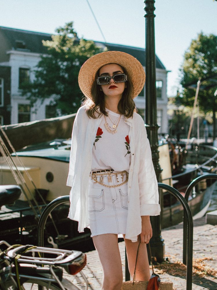 Contrast stitch white denim skirt, na-kd rose embroidered white t-shirt, linen shirt, straw bag, andreea birsan, couturezilla, cute summer outfit ideas 2018, zara mini denim skirt, rose shirt, nakd popular soldout rose embroidered tshirt, linen white shirt, boyfriend shirt, button up white shirt, oversized white shirt, how to wear a white shirt in a casual way, contrast stitching trend, the contrast stitch trend you need to try, how to up your basics, all white summer outfit, summer layering, gucci lookalike pearl sunglasses, 90s square sunglasses, statement sunglasses, budget alternative to gucci sunglasses, high street alternative, how to wear a mini skirt without looking vulgar, straw boater hat, straw hat, summer hat, wide brim hat, vintage straw tote bag, netherlands, visit netherlands, holland, schiedam, vintage finds, vintage raffia bag, vintage french bag, stripe silk scarf, tommy hilfiger red espadrilles, red shoes, red summer shoes, how to look Parisian chic, European summer street style inspiration for women 2017, pinterest chic outfit ideas for woman, summer outfit ideas, summer ootd inspiration, outfit of the day, ootd, fashion icon, style inspiration, fashionista, fashion inspiration, style inspo, what to wear in summer, how to look French, chic on a budget, zara outfit, mango, topshop, asos, river island, forever 21, urban outfitters, how to mix high end pieces with luxury ones, zara and Gucci,outfit alternatives for summer, tomboy chic, minimal outfit, tumblr girls photos, pictures, happy girl, women, smart casual outfits, the best outfit ideas 2017, what to wear when you don’t feel inspired, summer in Europe, weekend attire, uniform, French women in summer, European outfit ideas 2017, minimal chic outfit, how to stand out, the best outfit ideas for summer, the sunglasses you have seen everywhere on Instagram, glasses, uk fashion blogger, united kingdom, uk fashion blog, fashion and travel blog, Europe, women with style, street style, summer fashion trends 2017, best fashion ideas, styling, fall fashion, fall outfit, fall ootd, fall perfect, transitional dressing, best transitional outfit ideas, how to wear statement earrings, dressing for autumn, autumn outfit, winter outfit ideas for work and school 2017