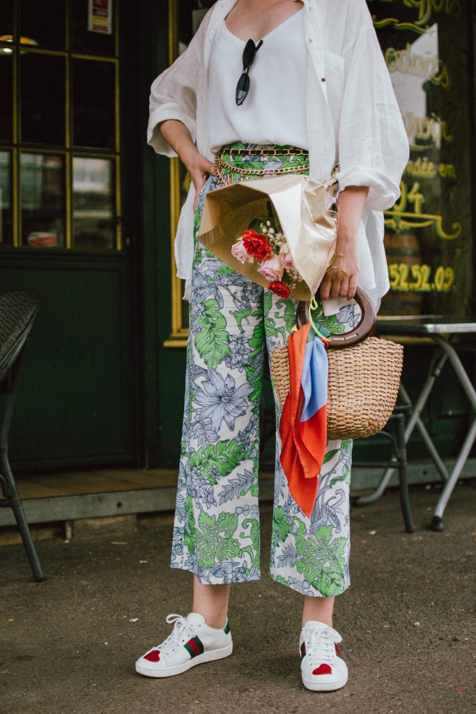 Zara floral print pants, flower print culottes, why you should wear floral print trousers, floral culottes, green blue and white pants, white cami top, mango camisole top, zara button down white linen shirt, boyfriend shirt, oversized shirt, gucci ace heart embroidered sneakers, gucci white sneakers, white leather sneakers, gucci trainers, h&m straw boater hat, summer straw bag with wooden handle, mini bag, the best summer bags, micro cat eye sunglasses, andreea birsan, couturezilla, cute summer outfit ideas 2018, sunnies, retro sunglasses, the asos sold out micro sunglasses, statement floral earrings, zara flower earrings, striped silk scarf, parisian cafe, andreea birsan travels to france, lille france, travel diary, what to wear when you travel to europe in summer, the perfect european summer outfit, how to wear a white shirt in different ways, handmade bags, bag made in thailand, wicker bag, natural fabric bag, how to wear florals, what to wear with floral printed pants, how to pull off culottes, what shoes to wear with culottes, tourist outfit, how to look Parisian chic, European summer street style inspiration for women 2017, pinterest chic outfit ideas for woman, summer outfit ideas, summer ootd inspiration, outfit of the day, ootd, fashion icon, style inspiration, fashionista, fashion inspiration, style inspo, what to wear in summer, how to look French, chic on a budget, zara outfit, mango, topshop, asos, river island, forever 21, urban outfitters, how to mix high end pieces with luxury ones, zara and Gucci,outfit alternatives for summer, tomboy chic, minimal outfit, tumblr girls photos, pictures, happy girl, women, smart casual outfits, the best outfit ideas 2017, what to wear when you don’t feel inspired, summer in Europe, weekend attire, uniform, French women in summer, European outfit ideas 2017, minimal chic outfit, how to stand out, the best outfit ideas for summer, the sunglasses you have seen everywhere on Instagram, glasses, uk fashion blogger, united kingdom, uk fashion blog, fashion and travel blog, Europe, women with style, street style, summer fashion trends 2017, best fashion ideas, styling, fall fashion, fall outfit, fall ootd, fall perfect, transitional dressing, best transitional outfit ideas, how to wear statement earrings, dressing for autumn, autumn outfit, winter outfit ideas for work and school 2017