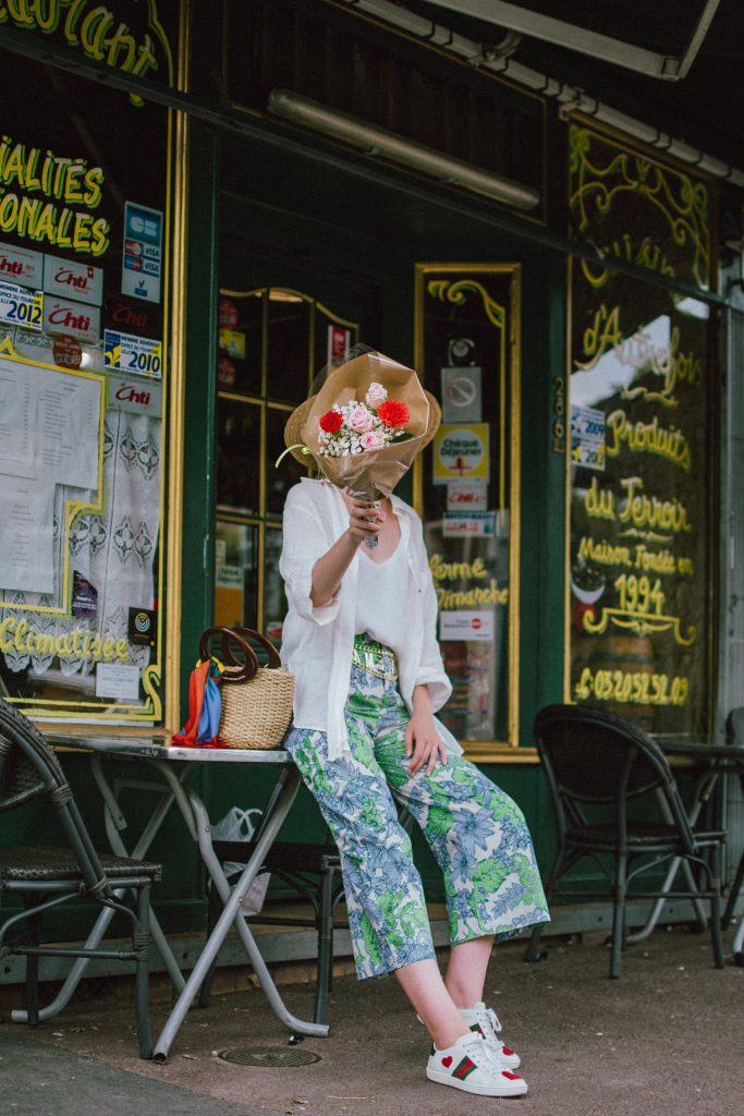 Zara floral print pants, flower print culottes, why you should wear floral print trousers, floral culottes, green blue and white pants, white cami top, mango camisole top, zara button down white linen shirt, boyfriend shirt, oversized shirt, gucci ace heart embroidered sneakers, gucci white sneakers, white leather sneakers, gucci trainers, h&m straw boater hat, summer straw bag with wooden handle, mini bag, the best summer bags, micro cat eye sunglasses, andreea birsan, couturezilla, cute summer outfit ideas 2018, sunnies, retro sunglasses, the asos sold out micro sunglasses, statement floral earrings, zara flower earrings, striped silk scarf, parisian cafe, andreea birsan travels to france, lille france, travel diary, what to wear when you travel to europe in summer, the perfect european summer outfit, how to wear a white shirt in different ways, handmade bags, bag made in thailand, wicker bag, natural fabric bag, how to wear florals, what to wear with floral printed pants, how to pull off culottes, what shoes to wear with culottes, tourist outfit, how to look Parisian chic, European summer street style inspiration for women 2017, pinterest chic outfit ideas for woman, summer outfit ideas, summer ootd inspiration, outfit of the day, ootd, fashion icon, style inspiration, fashionista, fashion inspiration, style inspo, what to wear in summer, how to look French, chic on a budget, zara outfit, mango, topshop, asos, river island, forever 21, urban outfitters, how to mix high end pieces with luxury ones, zara and Gucci,outfit alternatives for summer, tomboy chic, minimal outfit, tumblr girls photos, pictures, happy girl, women, smart casual outfits, the best outfit ideas 2017, what to wear when you don’t feel inspired, summer in Europe, weekend attire, uniform, French women in summer, European outfit ideas 2017, minimal chic outfit, how to stand out, the best outfit ideas for summer, the sunglasses you have seen everywhere on Instagram, glasses, uk fashion blogger, united kingdom, uk fashion blog, fashion and travel blog, Europe, women with style, street style, summer fashion trends 2017, best fashion ideas, styling, fall fashion, fall outfit, fall ootd, fall perfect, transitional dressing, best transitional outfit ideas, how to wear statement earrings, dressing for autumn, autumn outfit, winter outfit ideas for work and school 2017