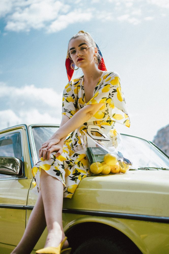 Lemon print midi dress, yellow slingback shoes, transparent tote bag, andreea birsan, couturezilla, cute summer outfit ideas 2018, lemon print dress, tie front lemon print dress, sicialian print, why you should wear a fruit print this summer, the prints that are hot right now, the best holiday dress, what you should wear on a summer holiday, warm weather midi dress, yellow and white midi tie front dress, top knot dress, vinyl tote bag, staud inspired bag, how to wear yellow, lemons, fruit print clothing, d&g inspired print dress, lemon printed dress, how to wear a midi dress, what shoes to wear with a midi dress, yellow suede slingback shoes, yellow kitten heel shoes, slingbacks, yellow shoes, how to pull off yellow shoes, the transparent bag trend, pcv bag, celine inspired plastic bag trend, the best bags from mango, silk striped scarf, scarf in hair, how to style a scarf in your ponytail, how to wear a scarf, best summer dresses, how to look Parisian chic, European summer street style inspiration for women 2017, pinterest chic outfit ideas for woman, summer outfit ideas, summer ootd inspiration, outfit of the day, ootd, fashion icon, style inspiration, fashionista, fashion inspiration, style inspo, what to wear in summer, how to look French, chic on a budget, zara outfit, mango, topshop, asos, river island, forever 21, urban outfitters, how to mix high end pieces with luxury ones, zara and Gucci,outfit alternatives for summer, tomboy chic, minimal outfit, tumblr girls photos, pictures, happy girl, women, smart casual outfits, the best outfit ideas 2017, what to wear when you don’t feel inspired, summer in Europe, weekend attire, uniform, French women in summer, European outfit ideas 2017, minimal chic outfit, how to stand out, the best outfit ideas for summer, the sunglasses you have seen everywhere on Instagram, glasses, uk fashion blogger, united kingdom, uk fashion blog, fashion and travel blog, Europe, women with style, street style, summer fashion trends 2017, best fashion ideas, styling, fall fashion, fall outfit, fall ootd, fall perfect, transitional dressing, best transitional outfit ideas, how to wear statement earrings, dressing for autumn, autumn outfit, winter outfit ideas for work and school 2017, clear lens aviator glasses, the clear lens glasses trend, geeky glasses, gold hoop earrings